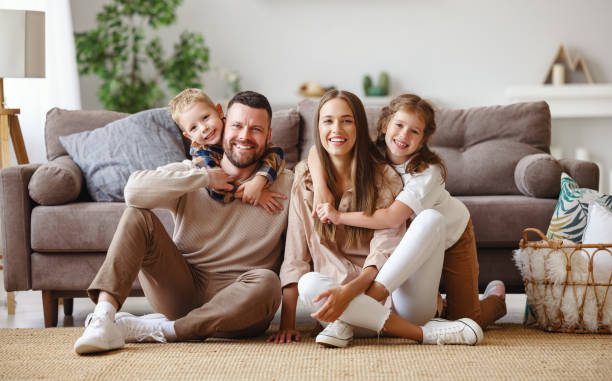 glückliche familie mutter vater und kinder zu hause auf der couch - familie stock-fotos und bilder