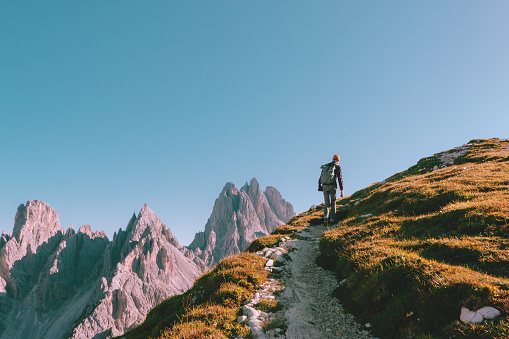 Hombre caminando solo en el borde de la roca y mirando hacia el horizonte. Alpes italianos cerca del Tre Cime di Lavaredo. photo