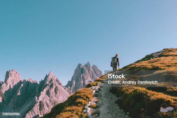 Man Hiking Alone On The Edge Of The Rock And Looking Towards The Horizon Italian Alps Near The Tre Cime Di Lavaredo Stock Photo - Download Image Now