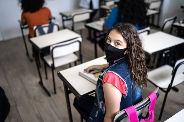 Portrait of an high school student wearing face mask in the classroom Portrait of an high school student wearing face mask in the classroom reopening photos stock pictures, royalty-free photos & images