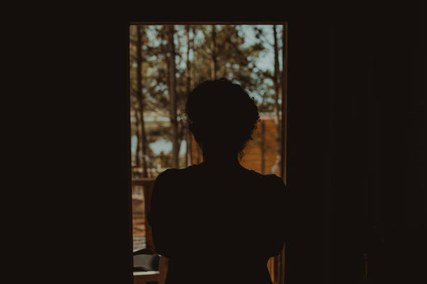 istock Rear View Of Silhouette Woman Standing By Window 1280161396