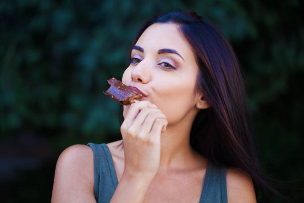 Cropped image of a woman enjoying apple pie with a scoop vanilla ice cream and chocolate sauce in a cafe