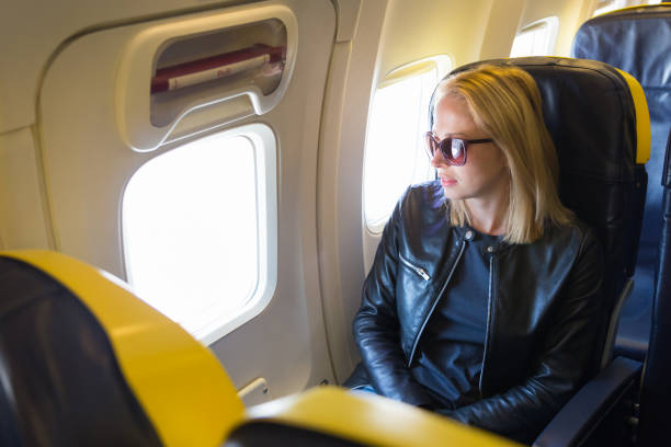 istock Beautiful Woman Sitting At Airplane 1280164728