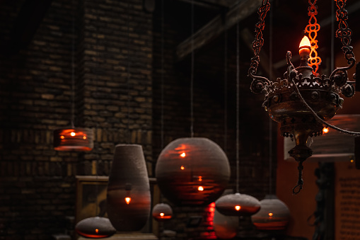 Aged grungy chandelier and lamps with dust and spider webs, light in darkness. Interior of abandoned manor or mansion. Halloween concept, background