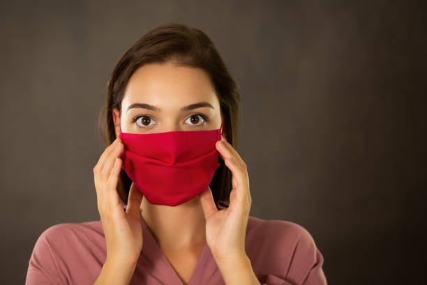 istock Frightened woman touching her pink face mask with fingers 1280166791