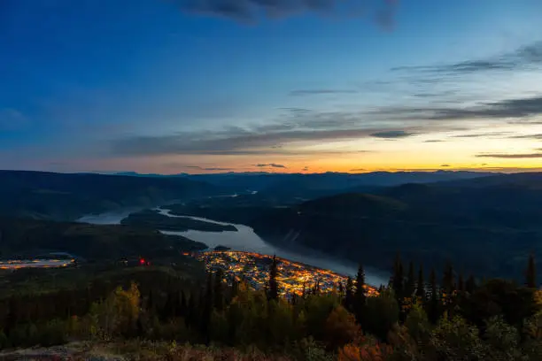 Panoramic View of Dawson City Lights from above at Night. Aerial Drone Shot. Taken from Midnight Dome Viewpoint, Yukon, Canada.