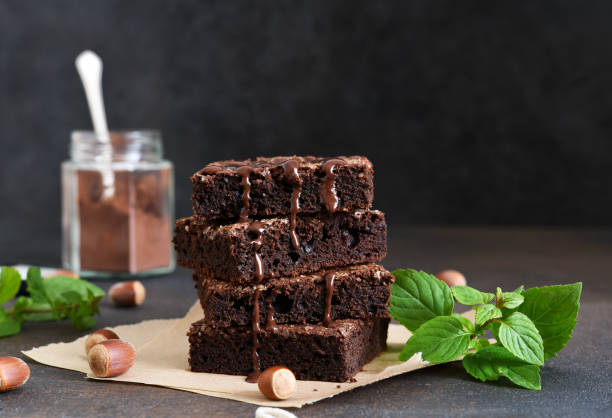 la classica torta americana è brownie. torta al cioccolato con noci su sfondo nero. - piazza delle vettovaglie foto e immagini stock