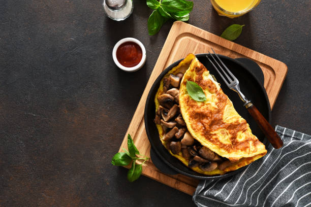 istock Omelet with mushrooms for breakfast with orange juice on the kitchen table. 1280171087