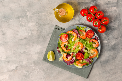 Shrimps with Fresh Salad, Lime, Tomatoes, Olive Oil, Herbs and Spices. Healthy Food Background