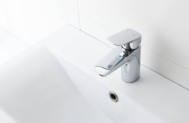 istock Silver clean shiny mixer on white sink in bathroom 1280174530