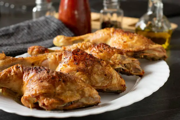 homemade oven baked chicken legs with crispy skin served on a white plate - ready to eat