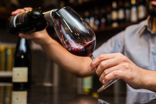 kelner wlewając czerwone wino w szklance restauracji. - wine decanter red restaurant zdjęcia i obrazy z banku zdjęć
