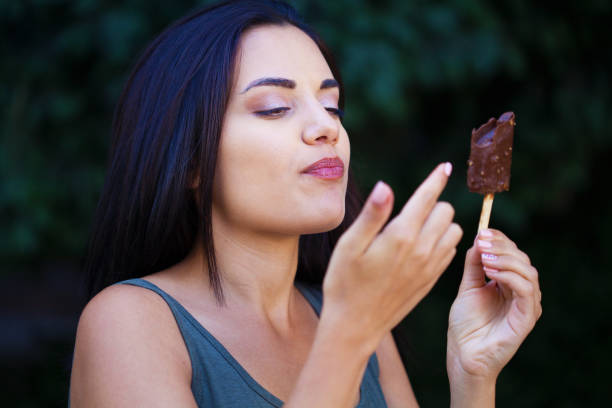istock Beautiful woman eating ice-cream 1280175973