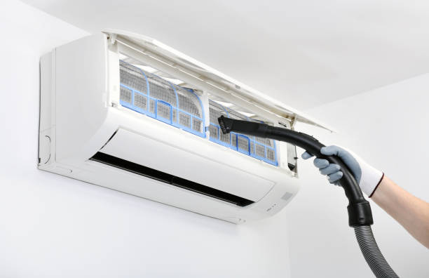 istock A worker is using a vacuum cleaner to clean the air conditioner.Air conditioner system on white wall room. Air conditioning.A white air conditioner is installed on a white wall in the apartment. 1280176470