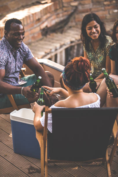 istock Friends opening beer bottles while hanging out on a picnic 1280180939