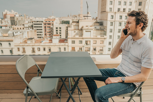 Businessman with smartphone on a rooftop in Barcelona