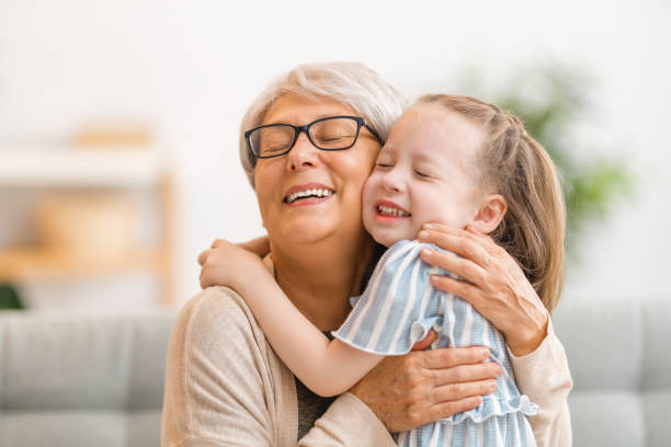 A nice girl and her grandmother enjoy sunny morning. Good time at home.
