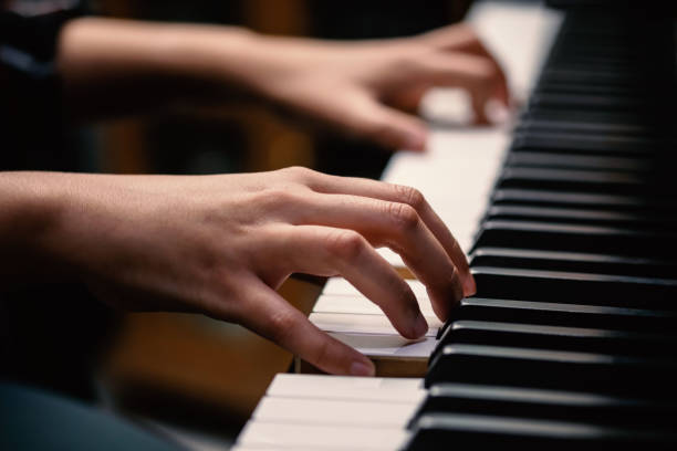 istock young woman performer hands playing piano. 1280185653