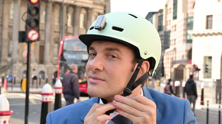 Portrait of businessman putting on and removing bike helmet