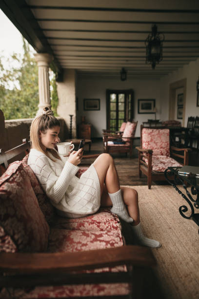 giovane donna che usa il telefono a casa - balcony house golf home interior foto e immagini stock