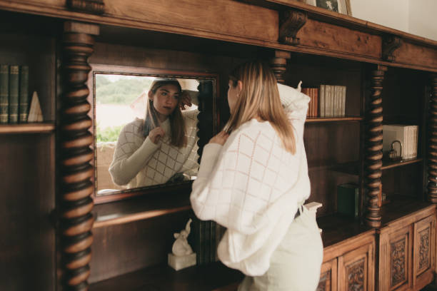 istock Young woman looking in the mirror 1280186740