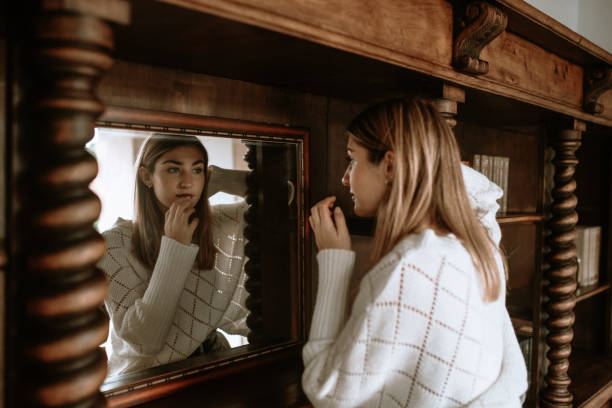 istock Young woman looking at herself in a mirror 1280189033