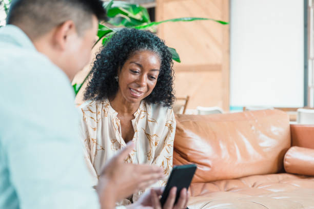 istock Unrecognizable man gestures as he shows co-worker something on phone 1280190340