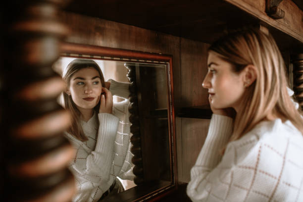 istock Young woman looking at herself in a mirror 1280190473