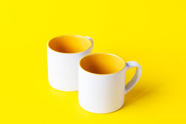 istock Empty coffee or tea white cup with yellow on yellow background. Copy space. 1280191119