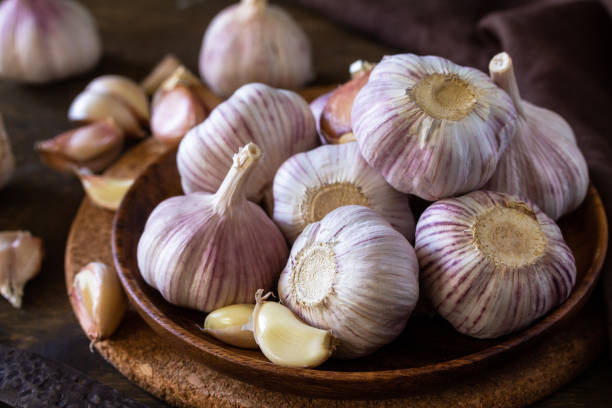 istock Garlic close-up. Garlic Cloves and Bulb on rustic wooden table. 1280191928