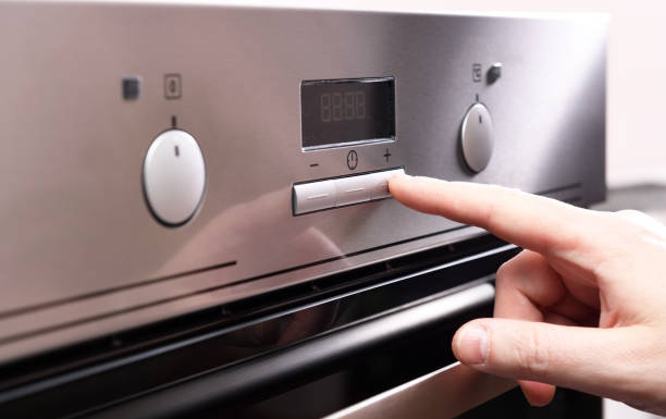 istock Male finger press button on control panel on oven The control panel of the electric oven. 1280192648