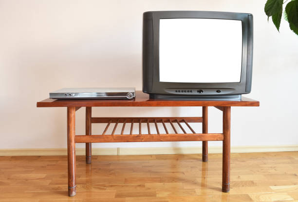 istock A DVD player and an outdated black TV with a blank white screen sit on a vintage table in a 1990s apartment block. 1280192873