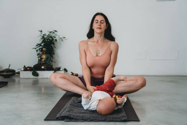 A young mother practicing yoga with her little child
