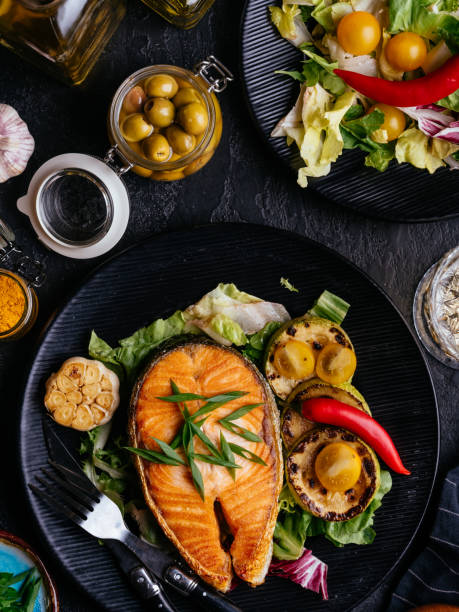 istock salmon steak baked on coals with vegetables on a black backgroun 1280196819