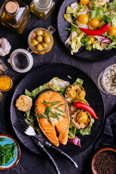 istock salmon steak baked on coals with vegetables on a black backgroun 1280196823