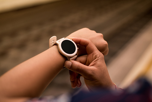 Close up image of young woman checking the smartwatch device on the underground. Railway on the background. in Valencia, Valencian Community, Spain
