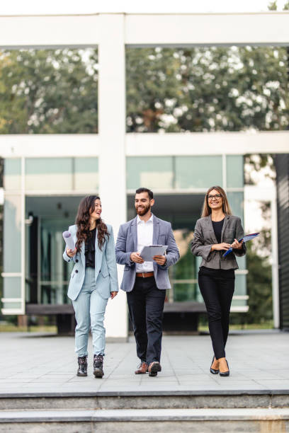 istock Three young colleagues talking in front of the office building 1280199238