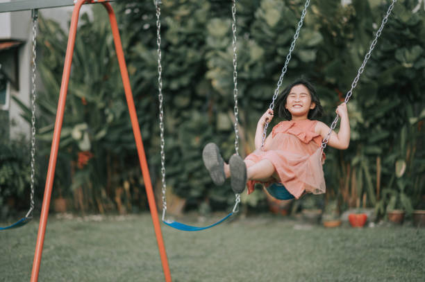 asian chinese Child young girl playing on swing staycation asian chinese Child playing on swing swing play equipment stock pictures, royalty-free photos & images