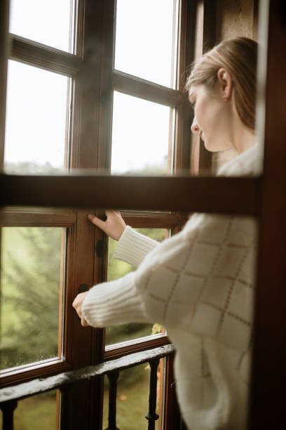 istock Young woman opening a window 1280199544