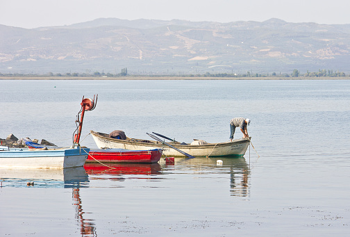 Bursa, Turkey - September 26, 2020: People are resting near the Lake of Iznik in Turkey and there are people on fishing boats is in the small harbour of Iznik, bursa, turkey.