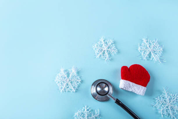 istock Flat lay medical Christmas composition with stethoscope, Santa Claus mitten and artificial snowflakes on blue background. Health care and medicne concept for card, calendar, cover. Copy space for text 1280202034