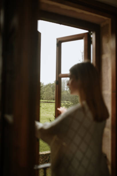 istock Young woman opening a window 1280202285