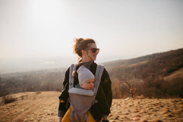 Active lifestyle from day one Photo of mother spending some quality time with her baby boy, hiking together and teaching him healthy lifestyle form day one baby carrier stock pictures, royalty-free photos & images