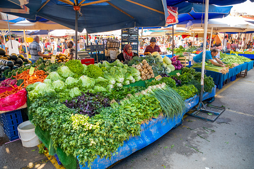 Union Square, Manhattan, New York, USA - August 23th 2023:  Man of Asian ethnicity standing in a market stall at the famous farmers market