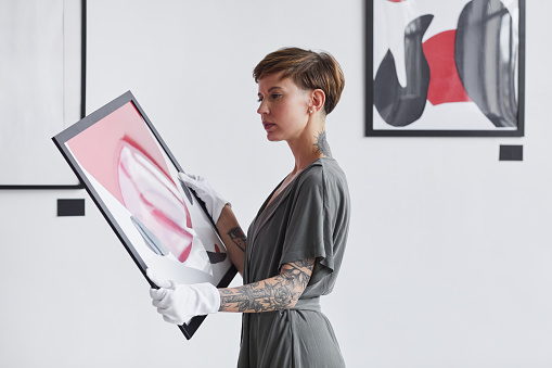 Mujer Creativa sosteniendo pintura en la galería de arte photo