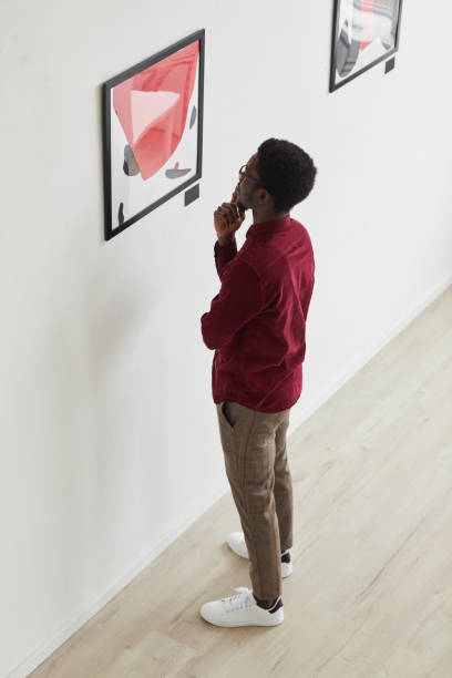African-American Man Looking at Modern Paintings