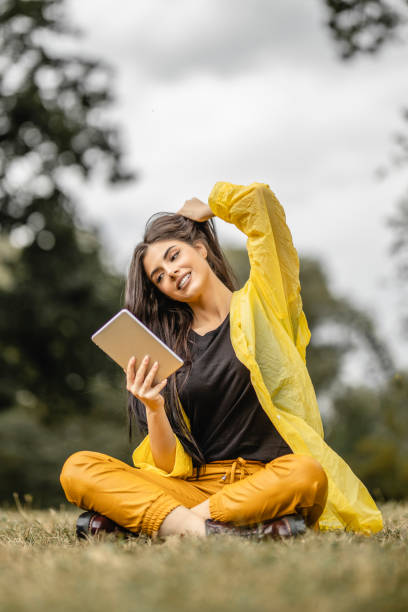 istock Beautiful woman reading e-book on digital tablet outdoors 1280211991