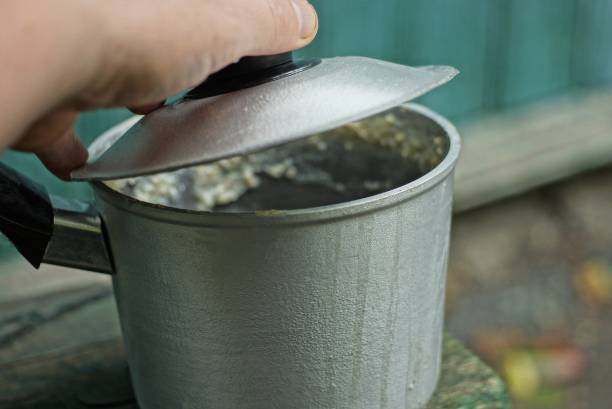 istock hand opens a metal lid on a gray dirty saucepan 1280212283