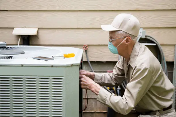Photo of Technician services outside AC unit.