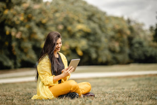 istock Beautiful woman reading e-book on digital tablet outdoors 1280215232